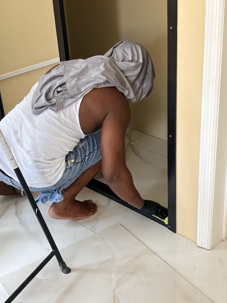 ELCS cleaner working carefully inside a low shelf